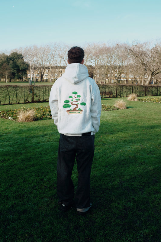 Model wearing ‘Grow With Care’ Hoodie, relaxed unisex fit